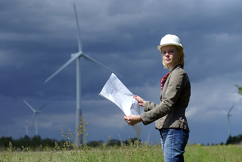 Woman with blueprints in front of wind turbine