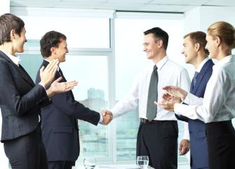 Labor relations specialists shaking hands in a meeting.
