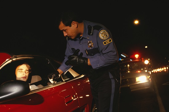 Police officer stopping a car at night
