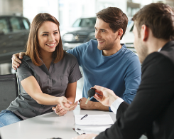 Couple at car dealership with salesperson