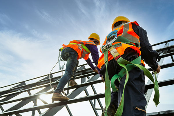 Two construction laborers working on a scaffold