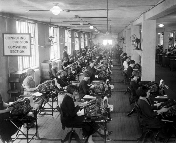 Image of female workers using calculating machines