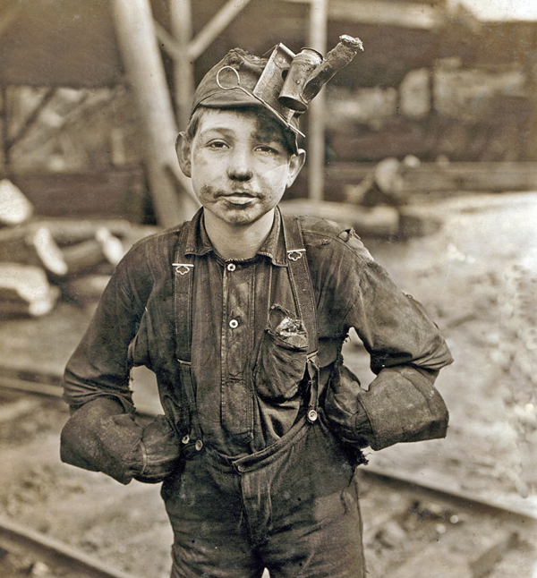 Tipple boy at West Virginia coal mine worked with the tipple, a device that tilted coal cars from the mine for unloading. Photo by Lewis Hine, 1908. Copyright: Everett Historical.